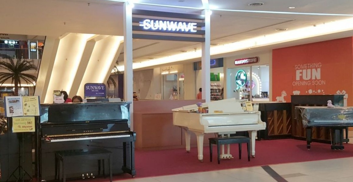 Upright pianos lined up on a piano shop floor